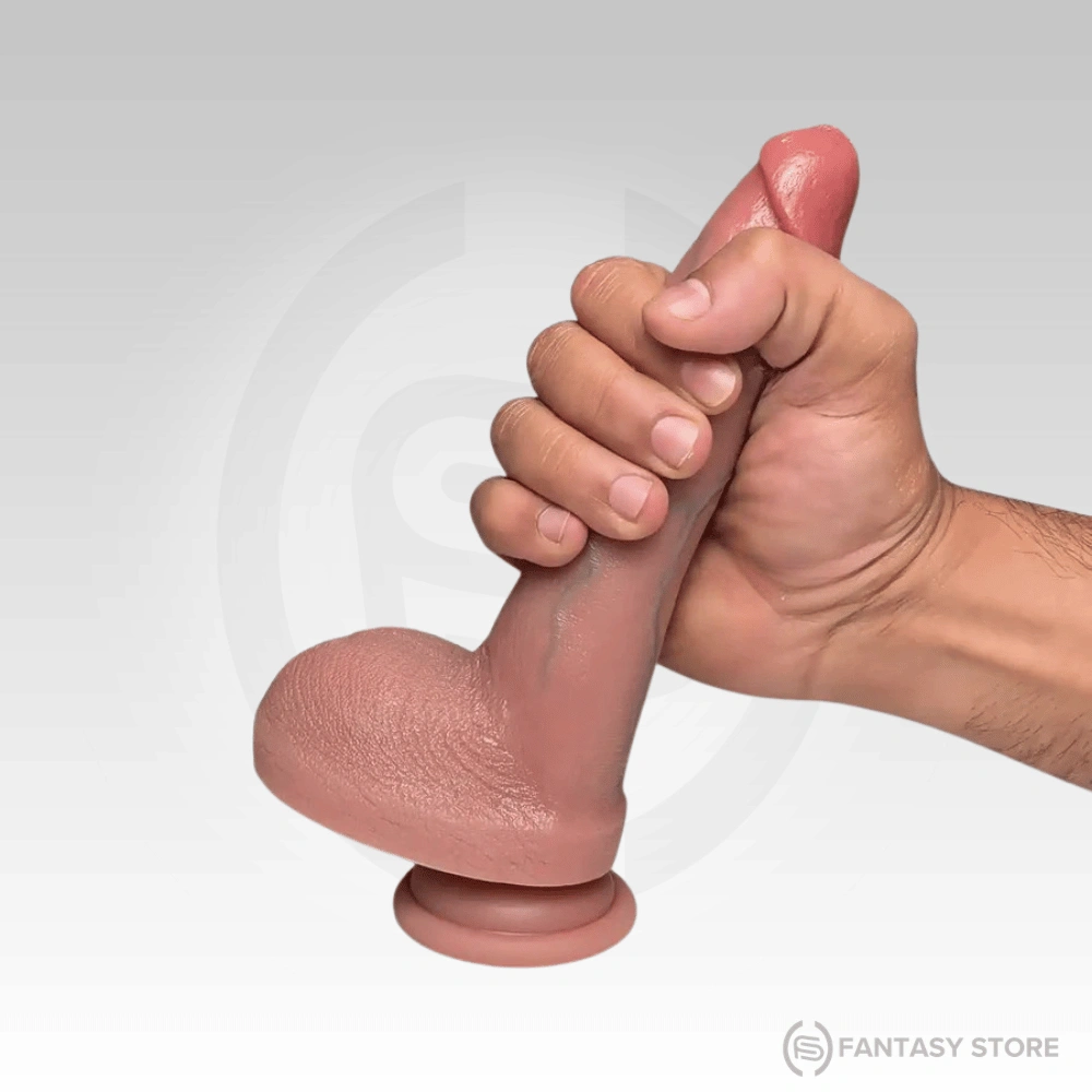 Hand holding a soft silicone dildo to show flexibility and approximate size.